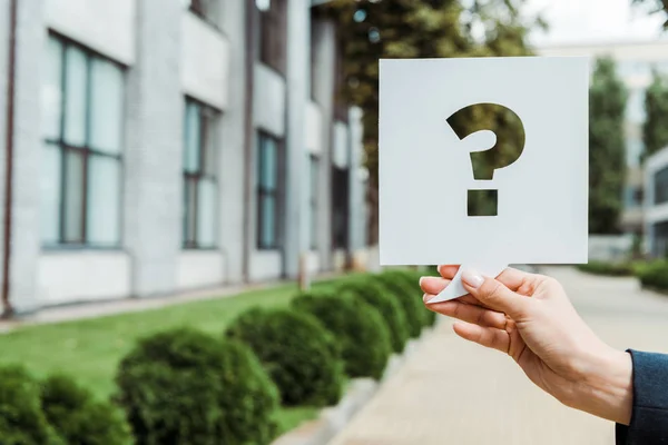 Cropped view of woman holding speech bubble with question mark outside — Stock Photo