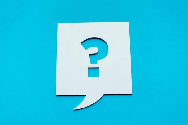 Top view of question mark on white speech bubble isolated on blue — Stock Photo