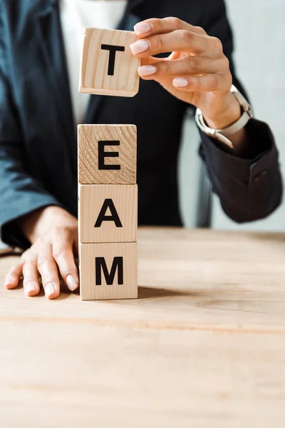 Cropped view of woman holding wooden cube with letters — Stock Photo