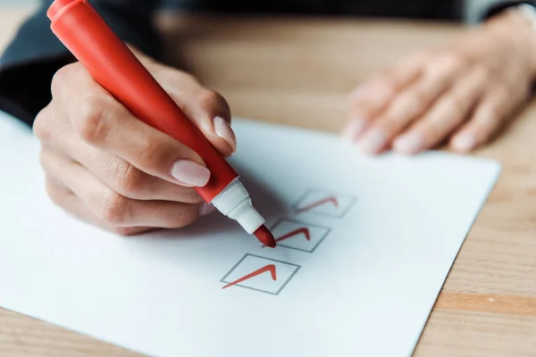 Cropped view of woman putting check park in check list — Stock Photo