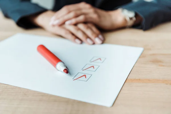 Cropped view of woman with clenched hands near check list — Stock Photo