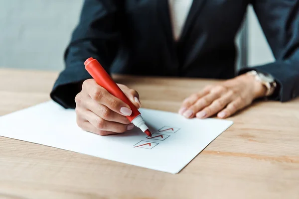 Vista recortada de la mujer de negocios poniendo check park en la lista de verificación - foto de stock