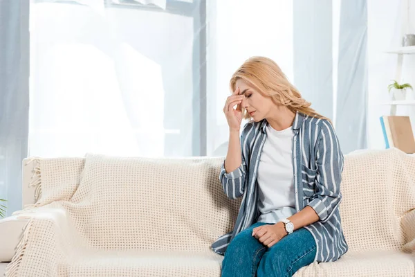 Verärgerte Frau mit geschlossenen Augen sitzt auf Sofa — Stockfoto