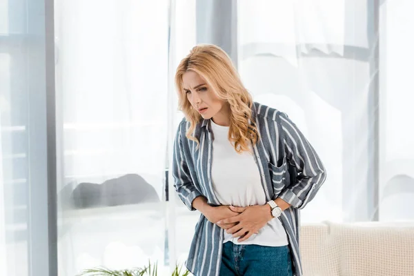 Upset woman having stomach ache at home — Stock Photo