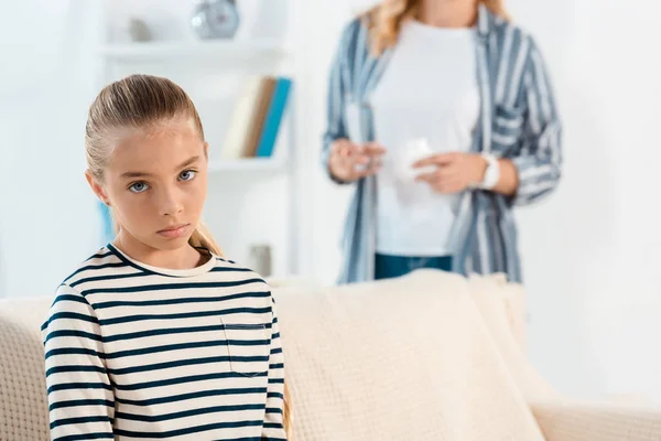 Selective focus of sick kid near mother in living room — Stock Photo