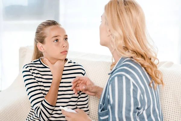 Diseased kid looking at mother with nasal spray at home — Stock Photo