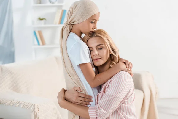 Sick kid hugging smiling mother at home — Stock Photo