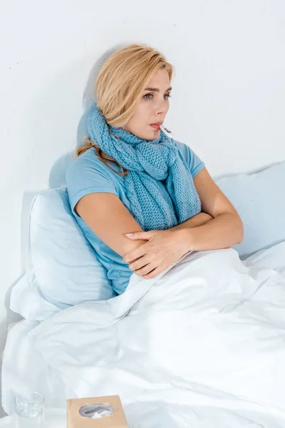 Mulher doente com braços cruzados segurando termômetro digital na boca no quarto — Fotografia de Stock