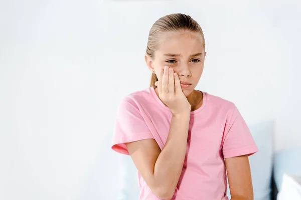 Trauriges Kind berührt Wange, während es Zahnschmerzen hat — Stockfoto
