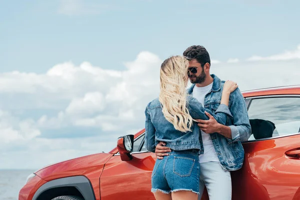 Blonde woman and handsome man in denim jackets hugging outside — Stock Photo