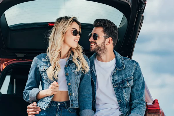 Attractive woman and handsome man in denim jackets smiling outside — Stock Photo