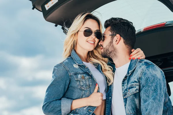 Attractive woman and handsome man in denim jackets hugging outside — Stock Photo