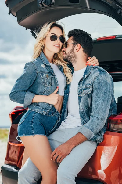 Привлекательная женщина и красивый мужчина в джинсовых куртках обнимаются снаружи — стоковое фото