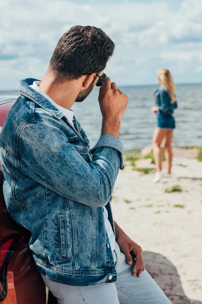 Back view of man in jacket and sunglasses looking at woman — Stock Photo