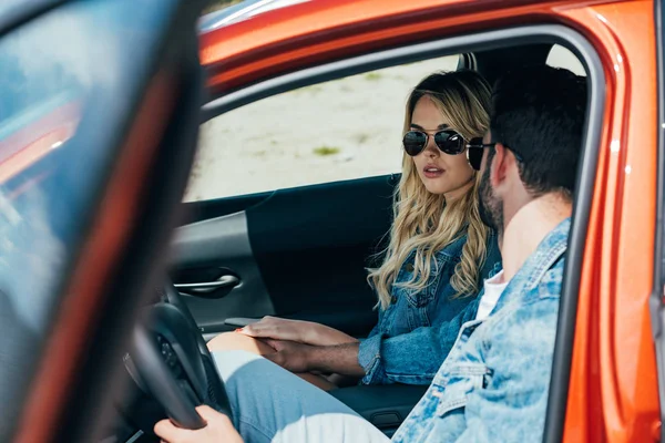 Attraktive Frau und Mann in Jacken sitzen im Auto — Stockfoto