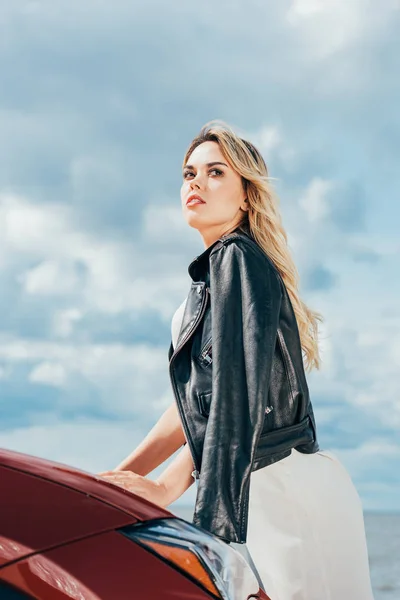 Attractive and blonde woman in black jacket looking away — Stock Photo