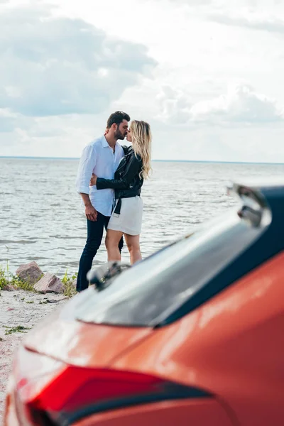 Atractiva mujer y hombre guapo abrazos y besos fuera - foto de stock