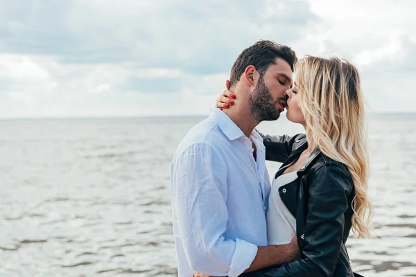 Attraktive Frau und schöner Mann umarmen und küssen sich draußen — Stockfoto