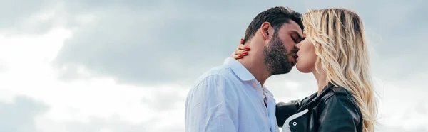 Panoramic shot of attractive woman and handsome man kissing outside — Stock Photo