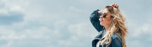 Панорамный снимок привлекательной женщины в джинсовой куртке, смотрящей в сторону — стоковое фото