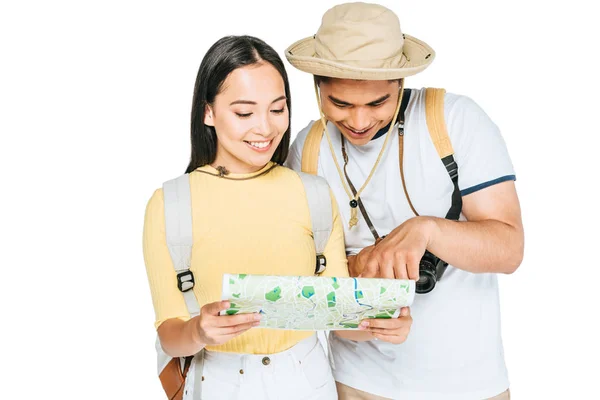 Two young asian tourists smiling while looking at map isolated on white — Stock Photo