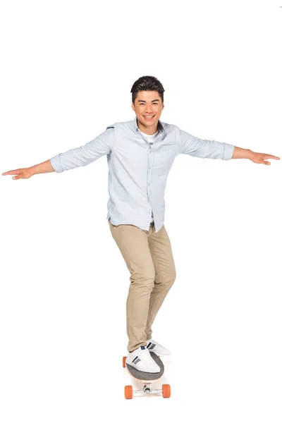 Joven guapo asiático hombre equitación longboard mientras mirando cámara en blanco fondo — Stock Photo