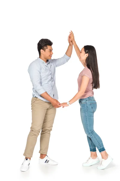 Guapo asiático hombre bailando con feliz novia en blanco fondo - foto de stock