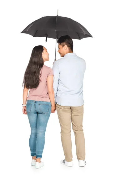 Junges asiatisches Paar unter Regenschirm stehend und Händchen haltend auf weißem Hintergrund — Stockfoto