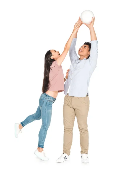 Young asian man and woman playing volleyball on white background — Stock Photo