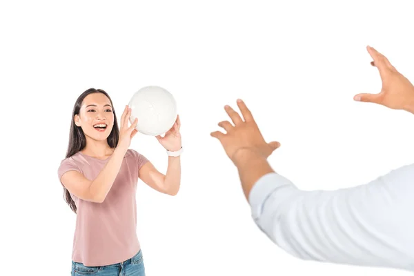 Обрізаний вид чоловіка, який грає у волейбол з привабливою азіатською дівчиною ізольовано на білому — стокове фото