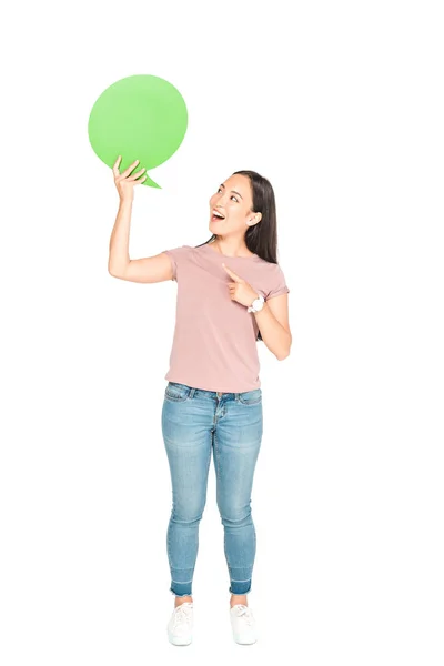 Cheerful asian girl pointing with finger at blank thought bubble on white background — Stock Photo
