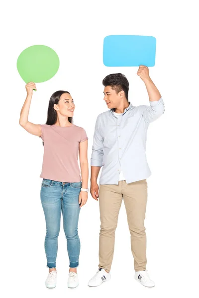 Smiling asian woman holding thought bubble looking at man with speech bubble on white background — Stock Photo