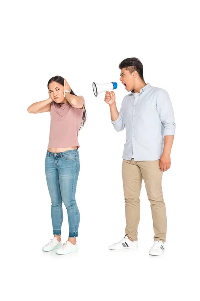Irritated asian woman yelling at girlfriend into megaphone on white background — Stock Photo