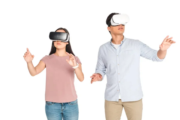 Young man and woman gesturing while using virtual reality headsets isolated on white — Stock Photo