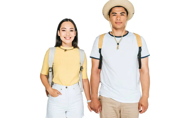 Deux joyeux asiatique touristes tenant la main et souriant à caméra isolé sur blanc — Photo de stock
