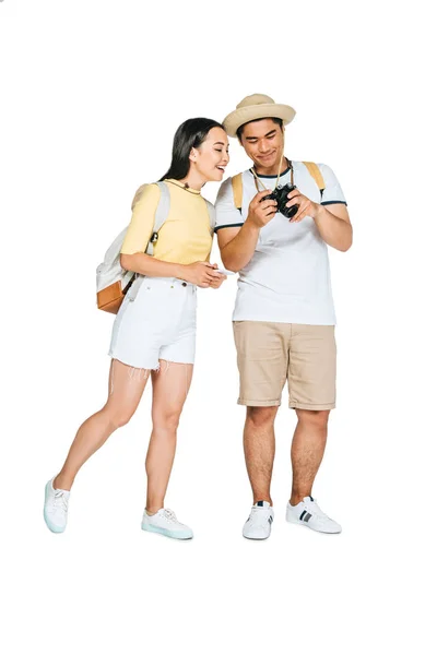Cheerful asian man showing digital camera to smiling girlfriend on white background — Stock Photo