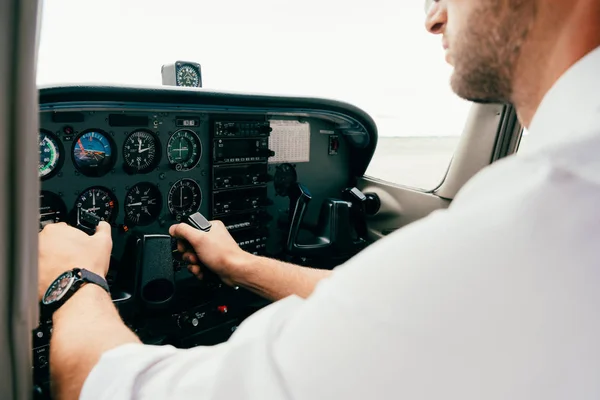Vista parcial del piloto en el timón del reloj de pulsera en el plano — Stock Photo