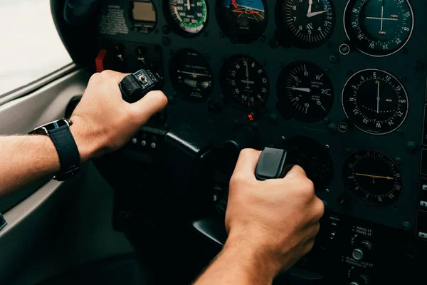 Teilansicht des Piloten in Armbanduhr, der das Steuer im Flugzeug hält — Stockfoto