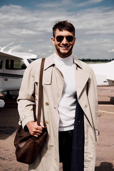 Man in coat standing near plane in sunny day — Stock Photo