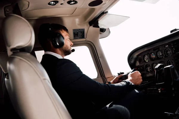 Piloto em desgaste formal sentado no avião e segurando — Fotografia de Stock