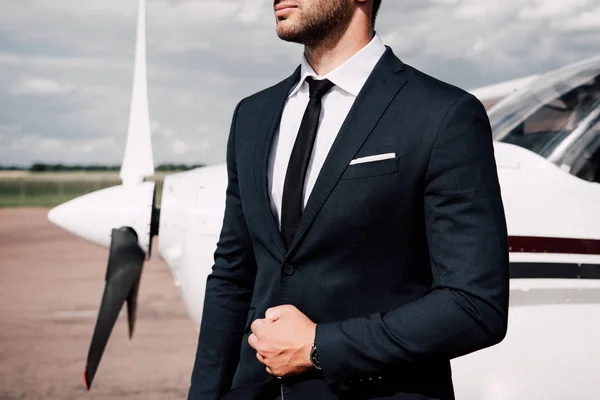 Teilansicht eines bärtigen Geschäftsmannes in offizieller Kleidung, der in der Nähe eines Flugzeugs steht — Stockfoto