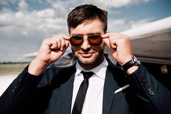 Confident businessman in formal wear standing near plane — Stock Photo