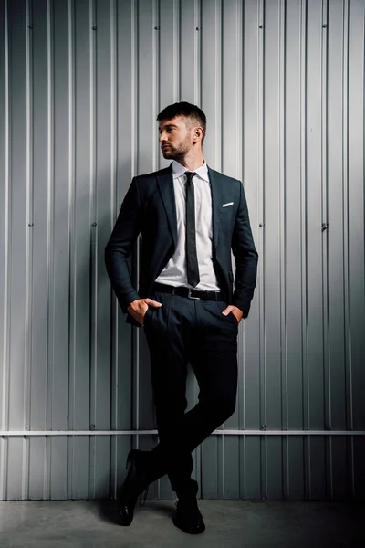 Piena vista lunghezza di uomo d'affari fiducioso in abbigliamento formale in piedi con le mani in tasca — Foto stock