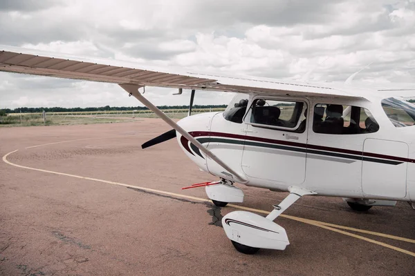 Plano blanco en aeródromo bajo cielo nublado nublado - foto de stock