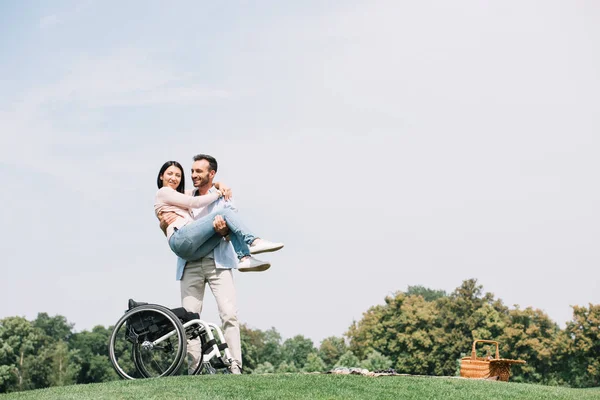 Alegre joven sosteniendo en manos feliz discapacitado novia - foto de stock