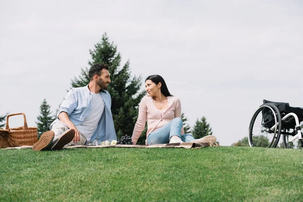 Heureuse femme handicapée reposant dans le parc avec beau petit ami — Photo de stock