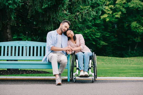 Hermosa mujer discapacitada con novio feliz descansando en el parque juntos - foto de stock
