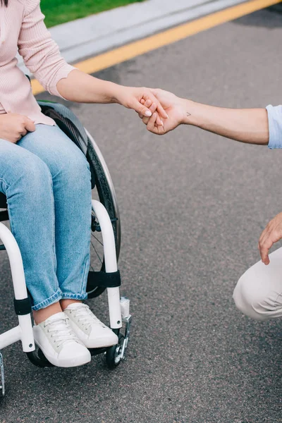 Vista ritagliata della donna disabile che si tiene per mano con il fidanzato — Foto stock