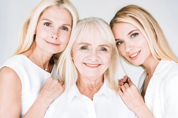 Retrato de mujeres rubias de tres generaciones aisladas en gris - foto de stock