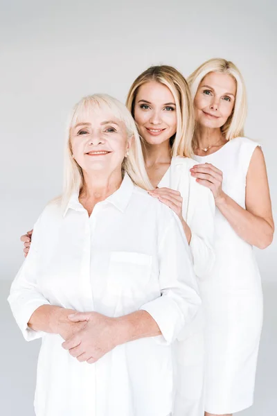 Mujeres rubias de tres generaciones de pie aisladas en gris - foto de stock